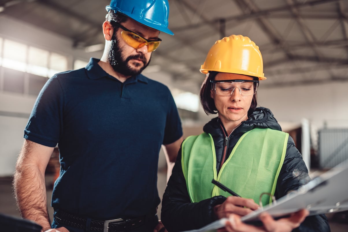 Workplace safety inspector writing a report at industrial factory